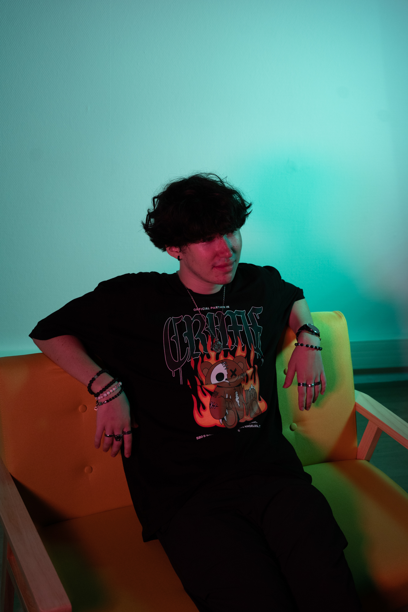 Photo garçon brun habillé en noir sur un canapé jaune