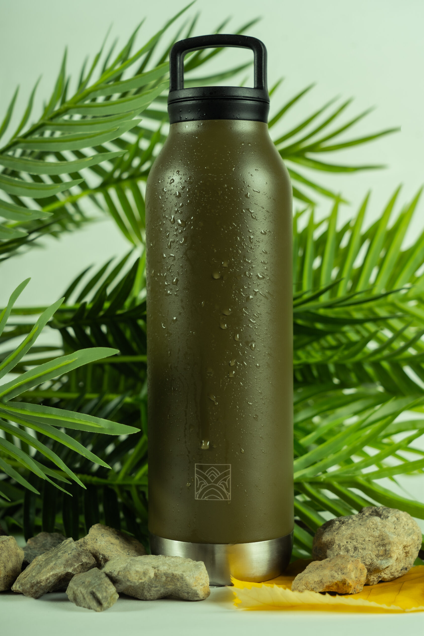 Photo de gourde isotherme sur fond blanc avec des feuilles et de l'eau